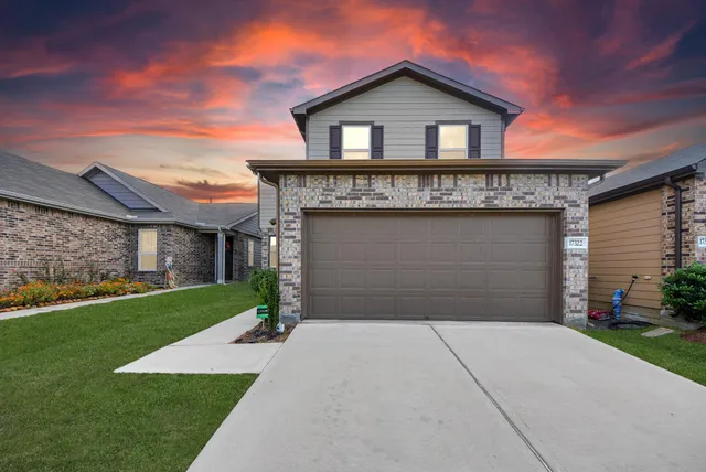 a front view of a house with a yard and garage