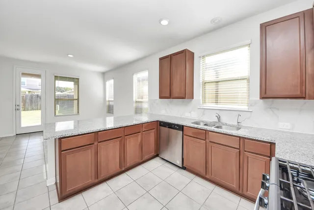 a kitchen with stainless steel appliances granite countertop a refrigerator and a stove top oven
