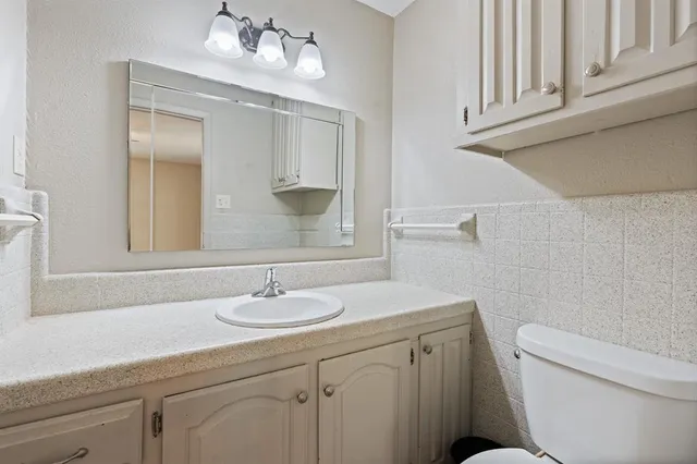 a bathroom with a sink a toilet and mirror