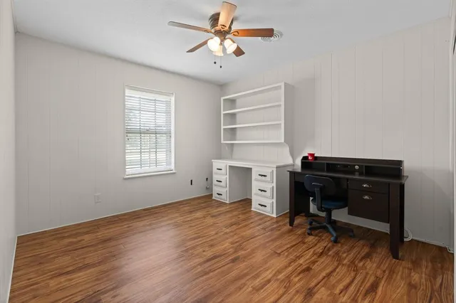 a view of a workspace with furniture and a window