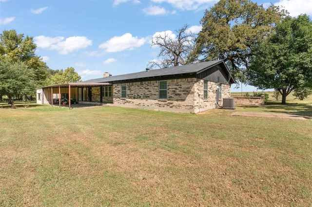 a view of a yard with a house and a large tree