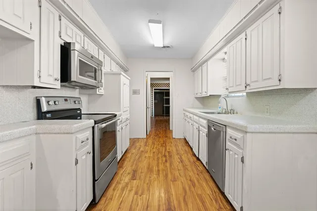 a kitchen with stainless steel appliances granite countertop a stove a sink and a refrigerator