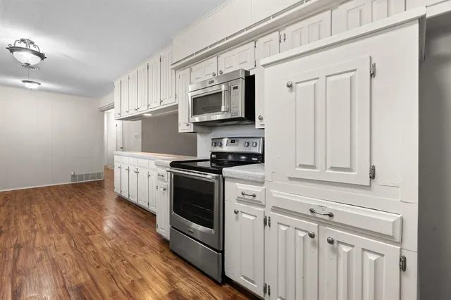 a kitchen with stainless steel appliances granite countertop a stove a sink and a microwave