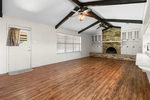 a view of empty room with wooden floor and fireplace