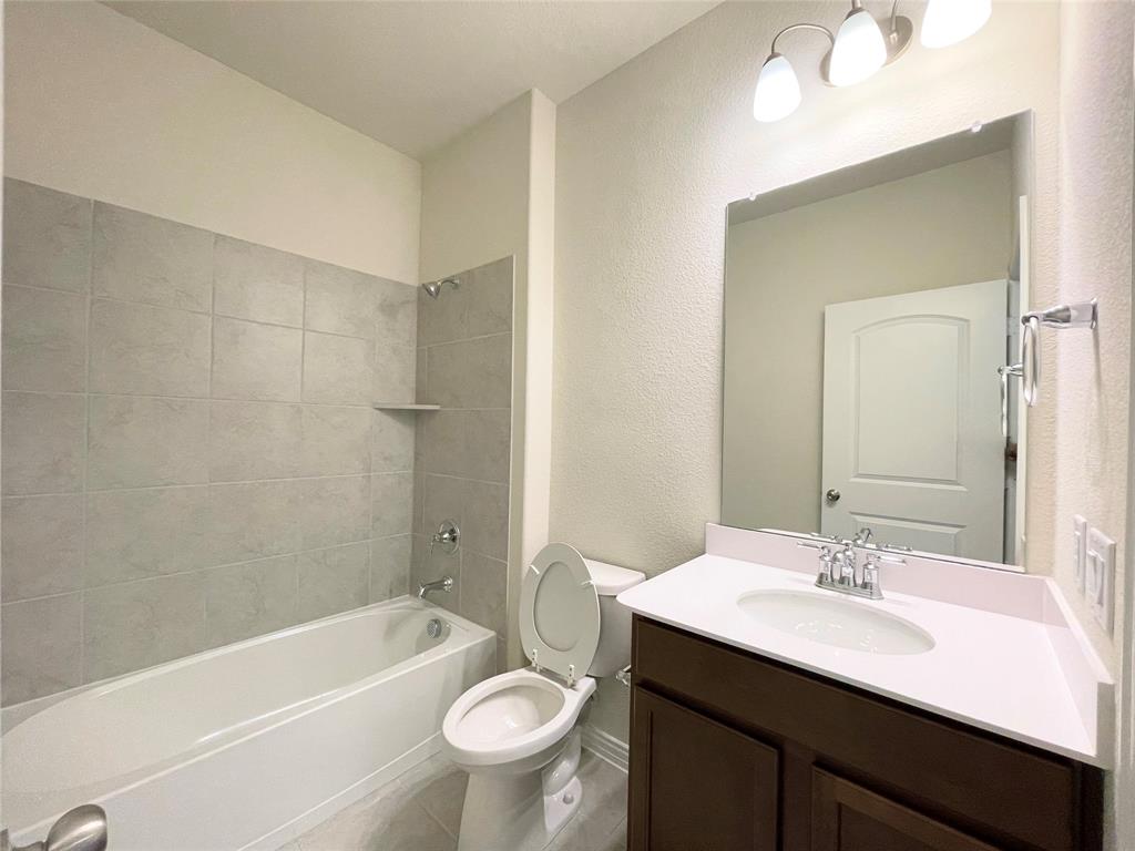 1805 Nelson Street Anna, TX 75409 - Photo 21 of 38 a bathroom with a sink a toilet a mirror a bathtub and shower