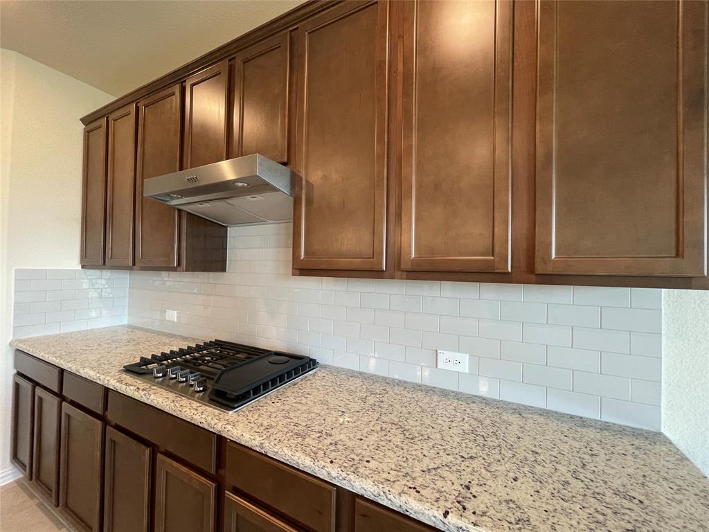 1805 Nelson Street Anna, TX 75409 - Photo 8 of 38 a kitchen with granite countertop cabinets and a stove top oven