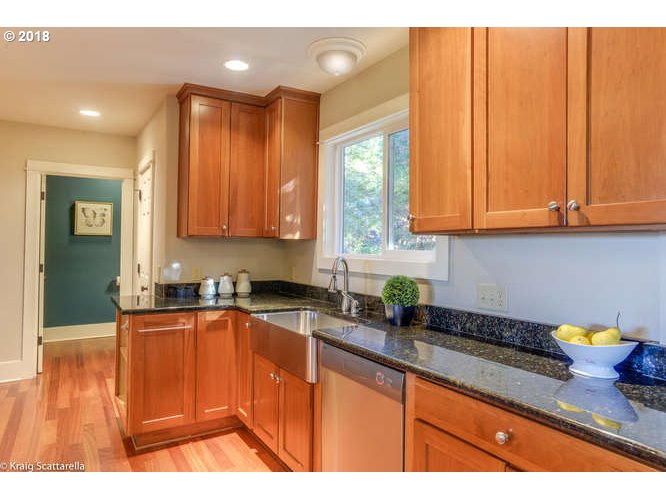 9506 Southwest Boones Ferry Road Portland, OR 97219 - Photo 11 of 32 a kitchen with stainless steel appliances granite countertop wooden cabinets a sink and dishwasher