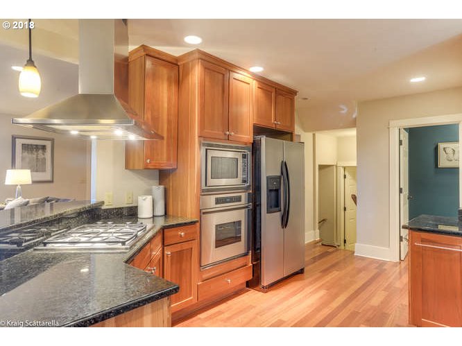 9506 Southwest Boones Ferry Road Portland, OR 97219 - Photo 13 of 32 a kitchen with stainless steel appliances granite countertop a refrigerator a stove and a sink