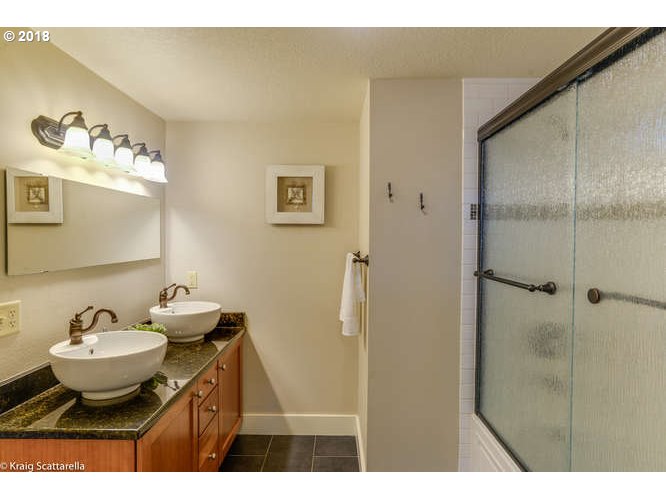 9506 Southwest Boones Ferry Road Portland, OR 97219 - Photo 17 of 32 a bathroom with a sink mirror and a shower