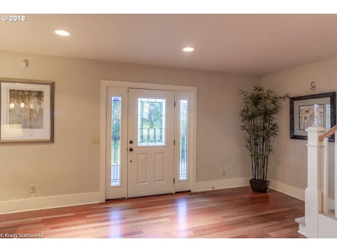 9506 Southwest Boones Ferry Road Portland, OR 97219 - Photo 2 of 32 an empty room with wooden floor and windows