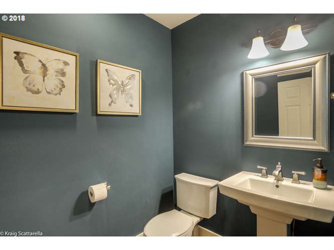 9506 Southwest Boones Ferry Road Portland, OR 97219 - Photo 21 of 32 a bathroom with a toilet sink and mirror