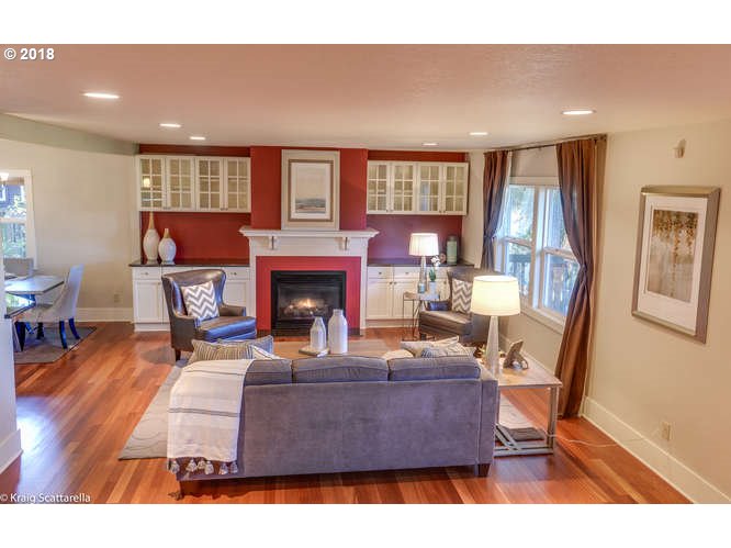 9506 Southwest Boones Ferry Road Portland, OR 97219 - Photo 3 of 32 a living room with furniture a fireplace and a flat screen tv