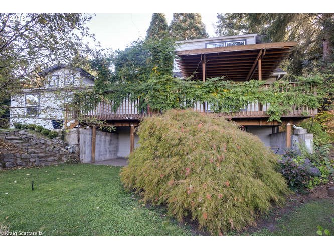 9506 Southwest Boones Ferry Road Portland, OR 97219 - Photo 31 of 32 a view of a backyard with table and chairs with wooden fence