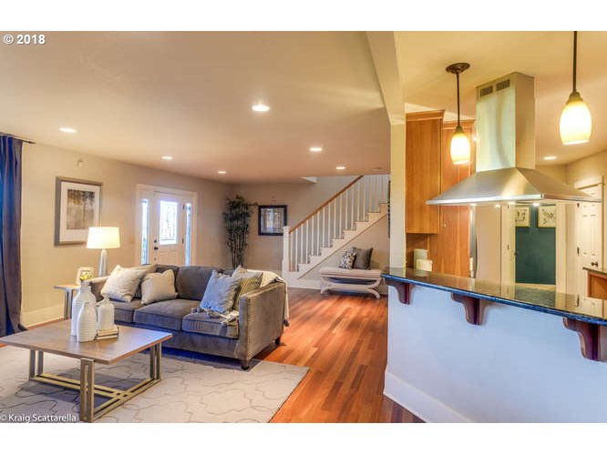 9506 Southwest Boones Ferry Road Portland, OR 97219 - Photo 6 of 32 a living room with furniture a wooden floor and a chandelier