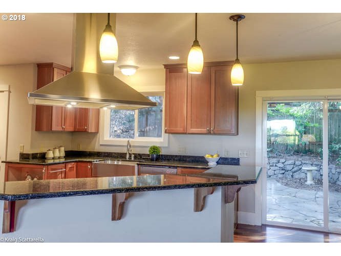 9506 Southwest Boones Ferry Road Portland, OR 97219 - Photo 7 of 32 a kitchen with a sink cabinets and window