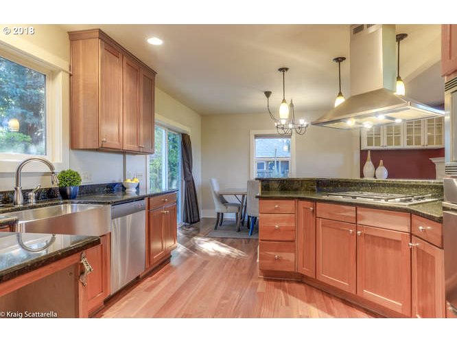 9506 Southwest Boones Ferry Road Portland, OR 97219 - Photo 9 of 32 a kitchen with granite countertop a sink cabinets and wooden floor