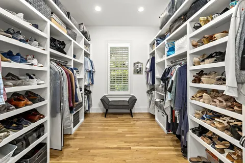 a view of walk in closet with clothes and shoes