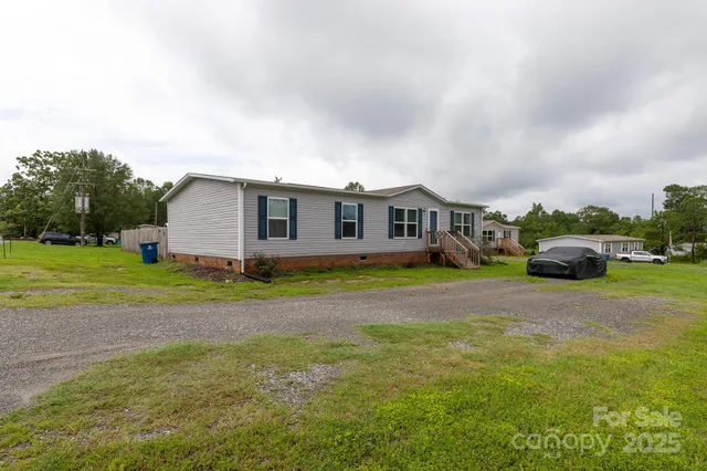a view of a house with a big yard and large trees