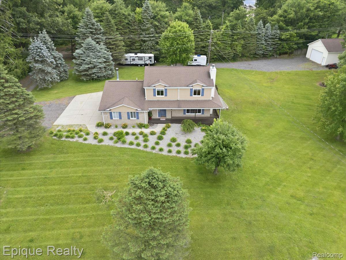 1221 Rhodes Road Lake Orion, MI 48360 - Photo 69 of 72 Expansive property featuring a two-story residence with a covered front porch, blue shutters, and a light-colored exterior