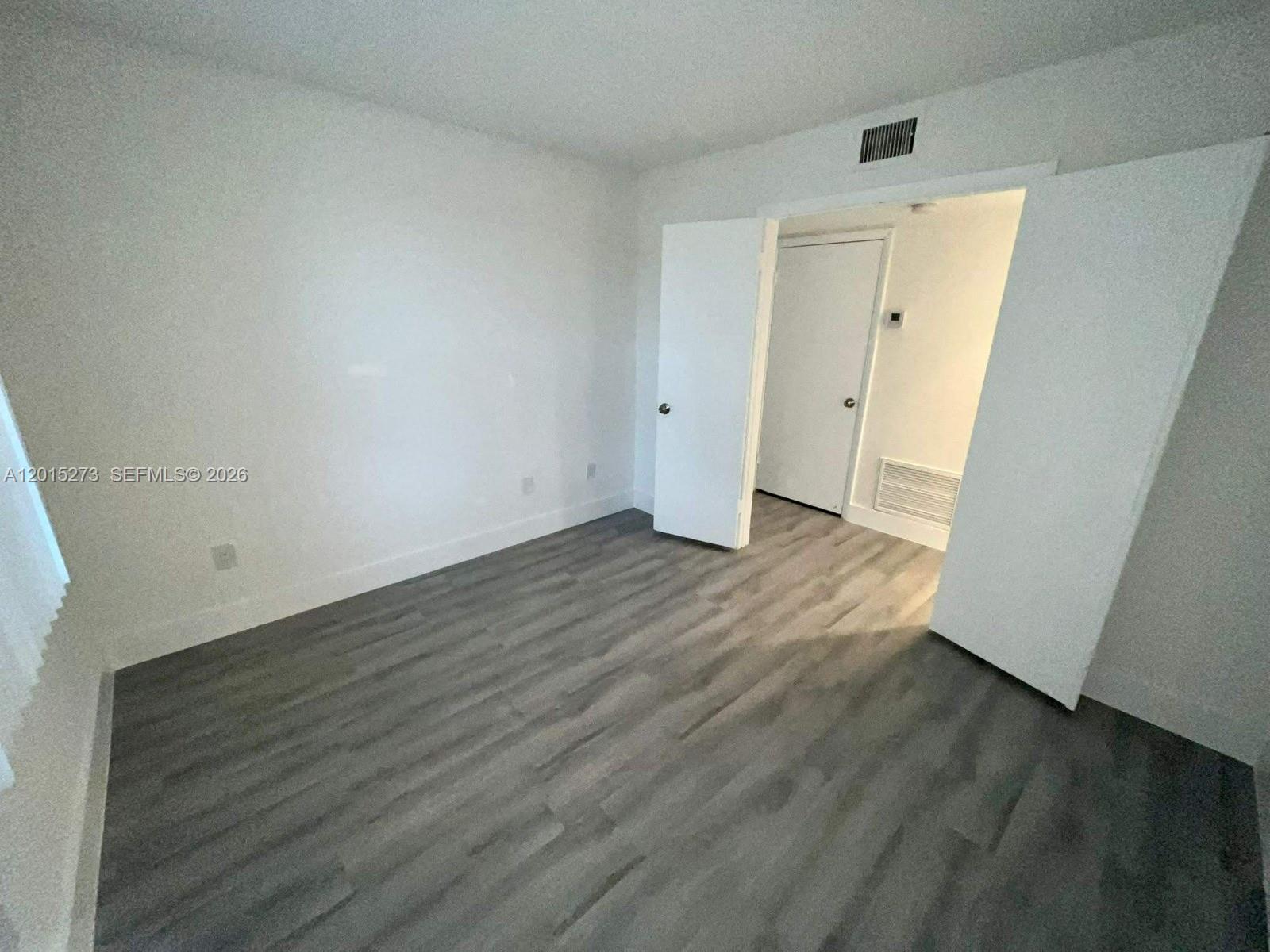 4561 West McNab Road, Unit 17 Pompano Beach, FL 33069 - Photo 6 of 11 a view of an empty room with wooden floor