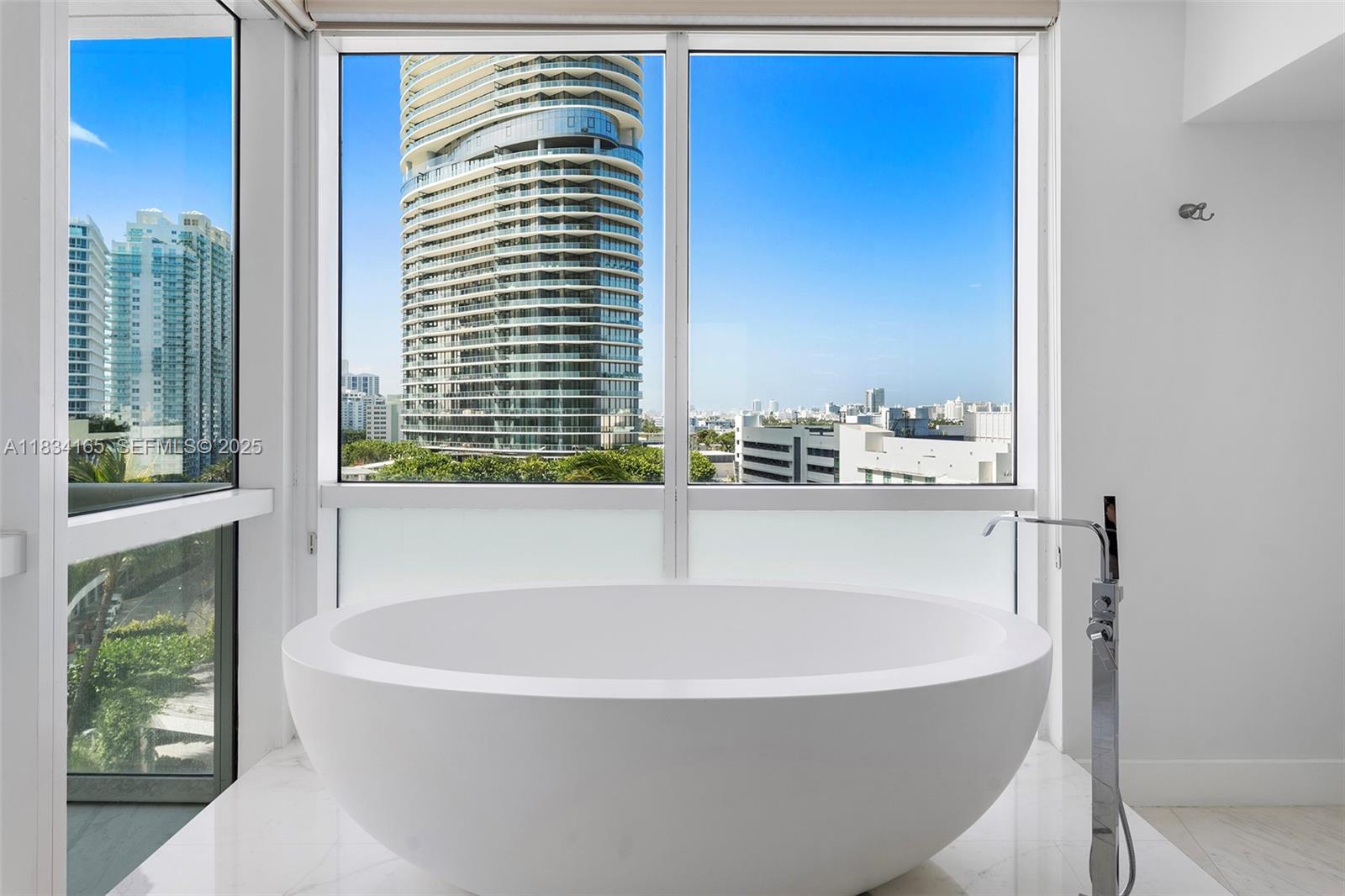 450 Alton Road, Unit 901902 Miami Beach, FL 33139 - Photo 55 of 100 a white bath tub sitting in a bathroom next to a window
