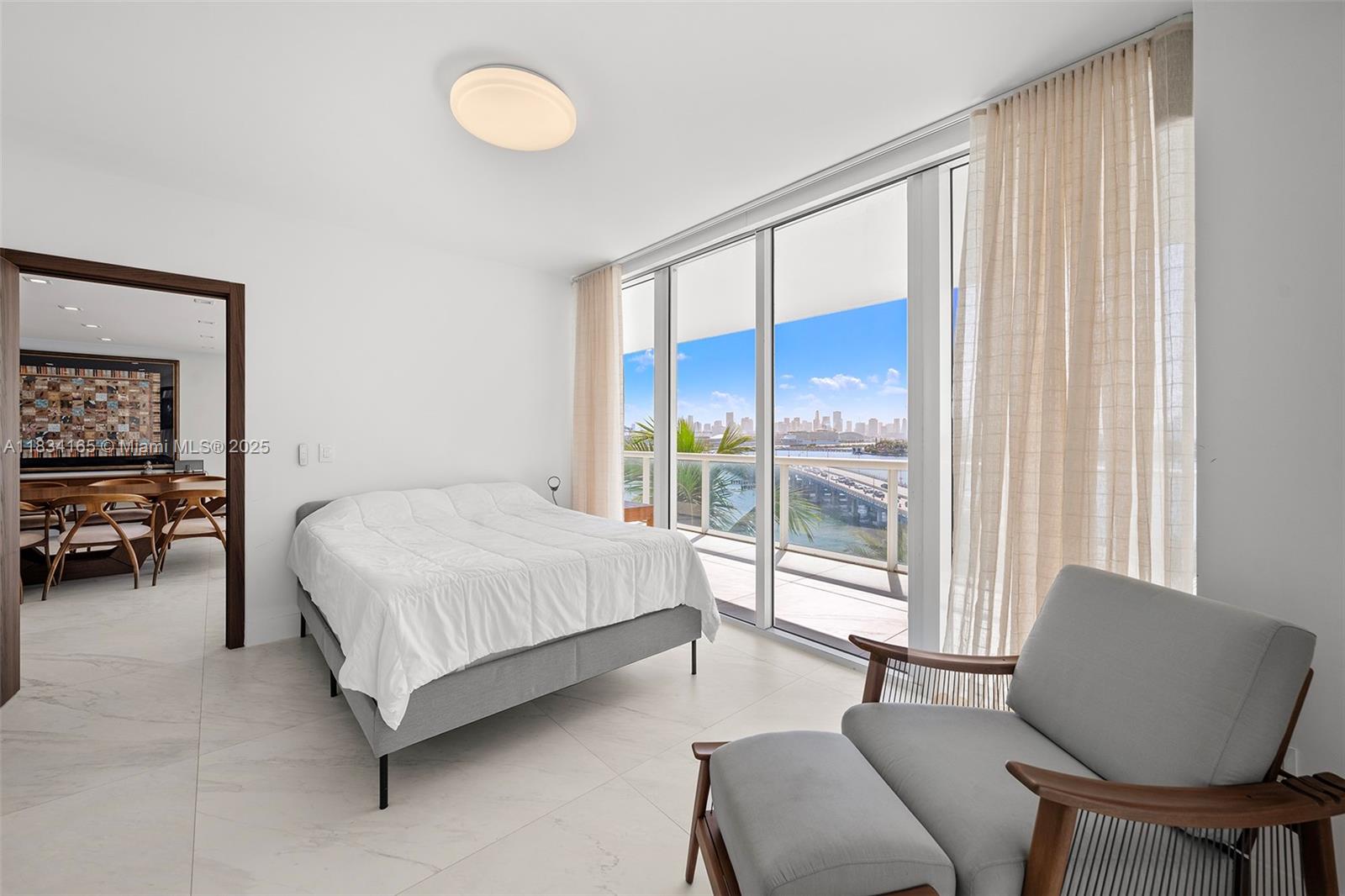 450 Alton Road, Unit 901902 Miami Beach, FL 33139 - Photo 61 of 100 a spacious bedroom with a bed and a chair