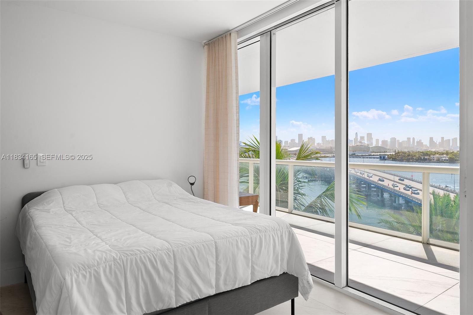 450 Alton Road, Unit 901902 Miami Beach, FL 33139 - Photo 64 of 100 a bedroom with a large window and a balcony