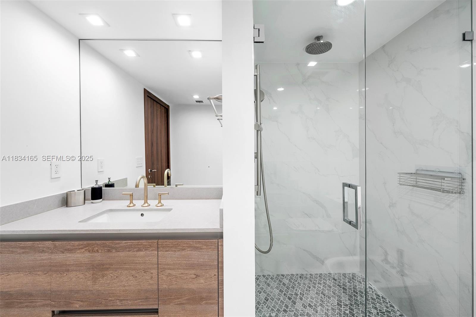 450 Alton Road, Unit 901902 Miami Beach, FL 33139 - Photo 69 of 100 a bathroom with a sink and mirror