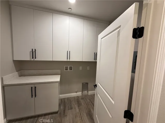 a view of walk in closet with clothes and white wooden cabinets