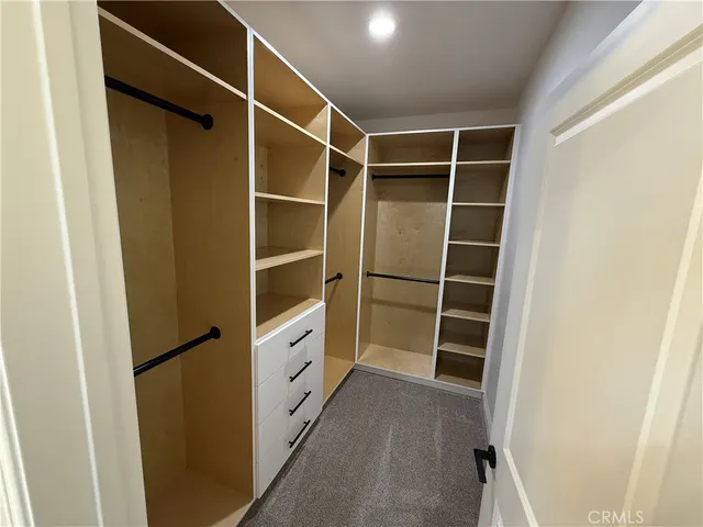 a view of walk in closet with empty racks