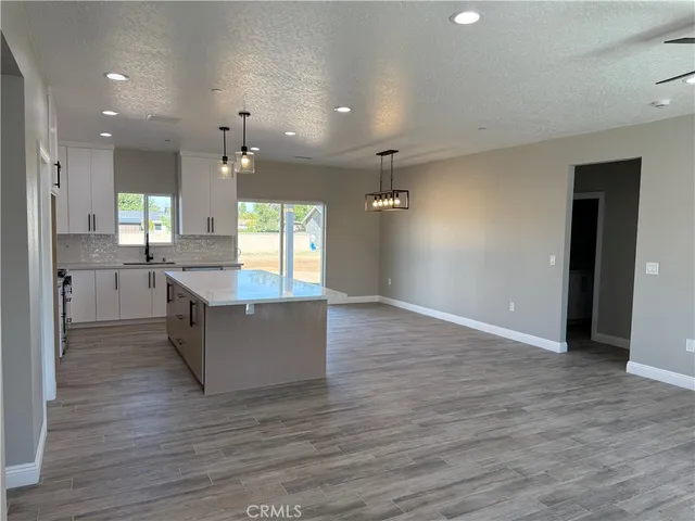 a large kitchen with granite countertop a large counter top and stainless steel appliances