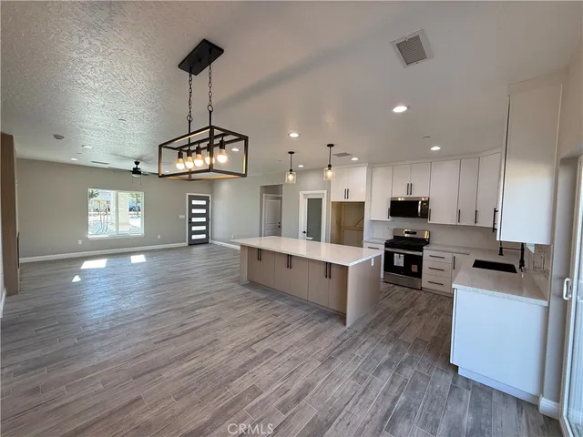a large kitchen with cabinets wooden floor and stainless steel appliances
