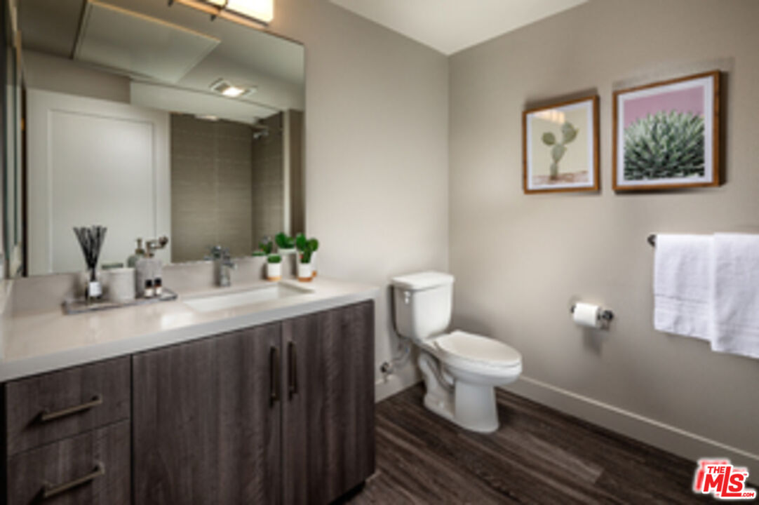 687 South Hobart Boulevard, Unit 327 Los Angeles, CA 90005 - Photo 18 of 21 a bathroom with a toilet sink and mirror
