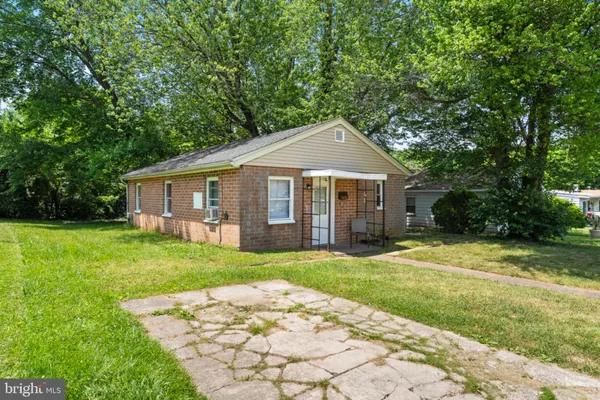 a front view of a house with a yard and trees