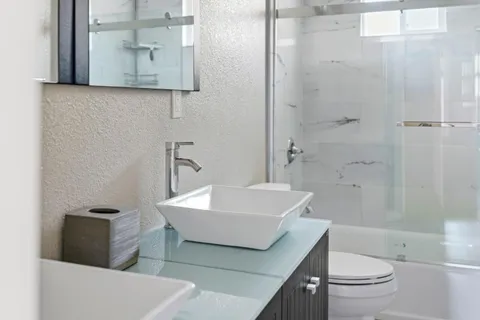 a bathroom with a sink a toilet and shower
