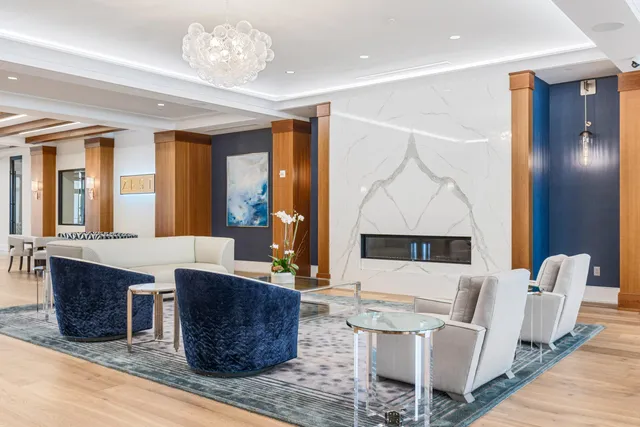 a living room with furniture a fireplace and a chandelier