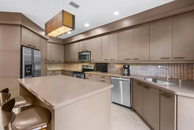 a kitchen with stainless steel appliances a refrigerator sink and cabinets