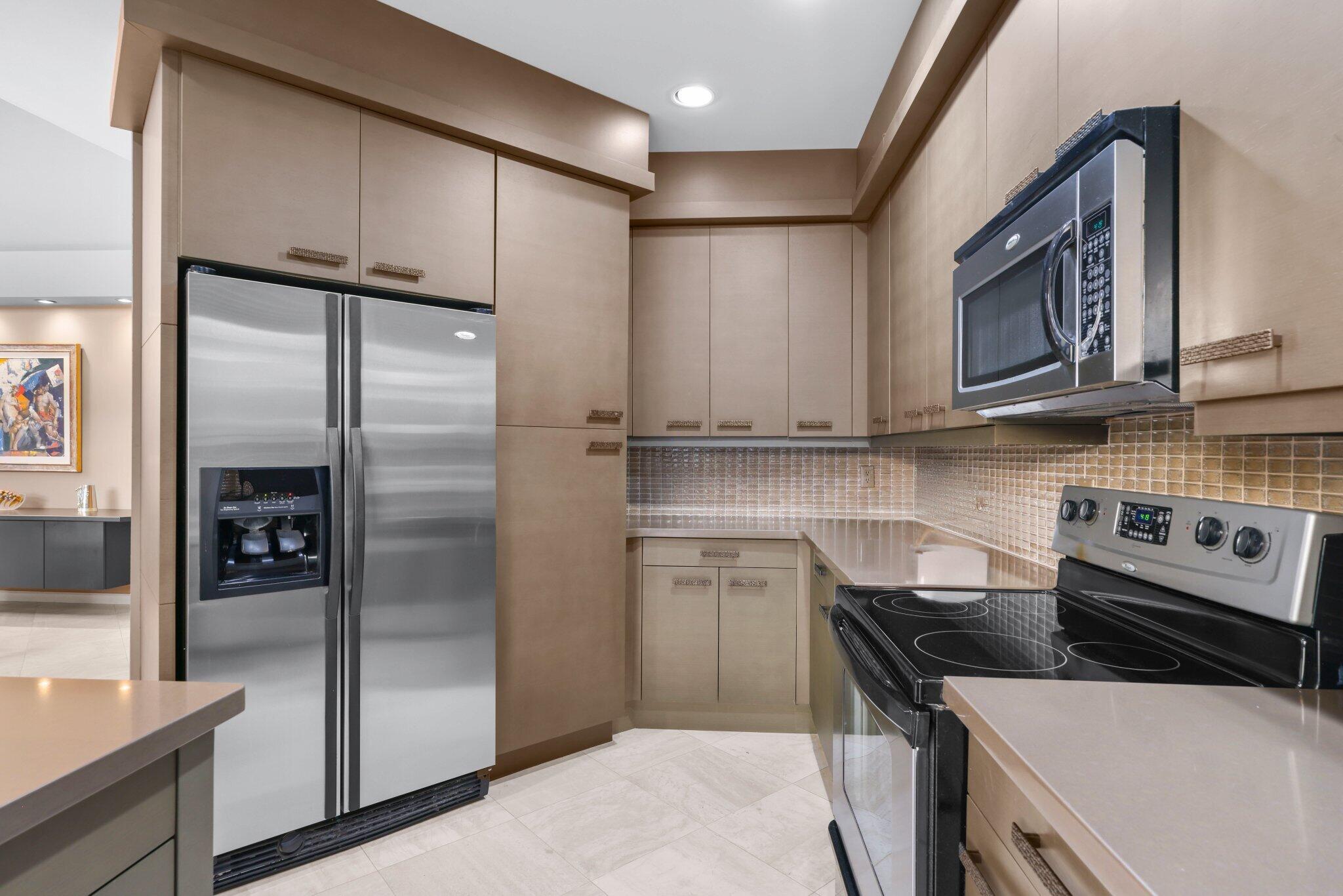 2595 Northwest 53rd Street Boca Raton, FL 33496 - Photo 6 of 48 a kitchen with stainless steel appliances granite countertop a stove a refrigerator and a sink