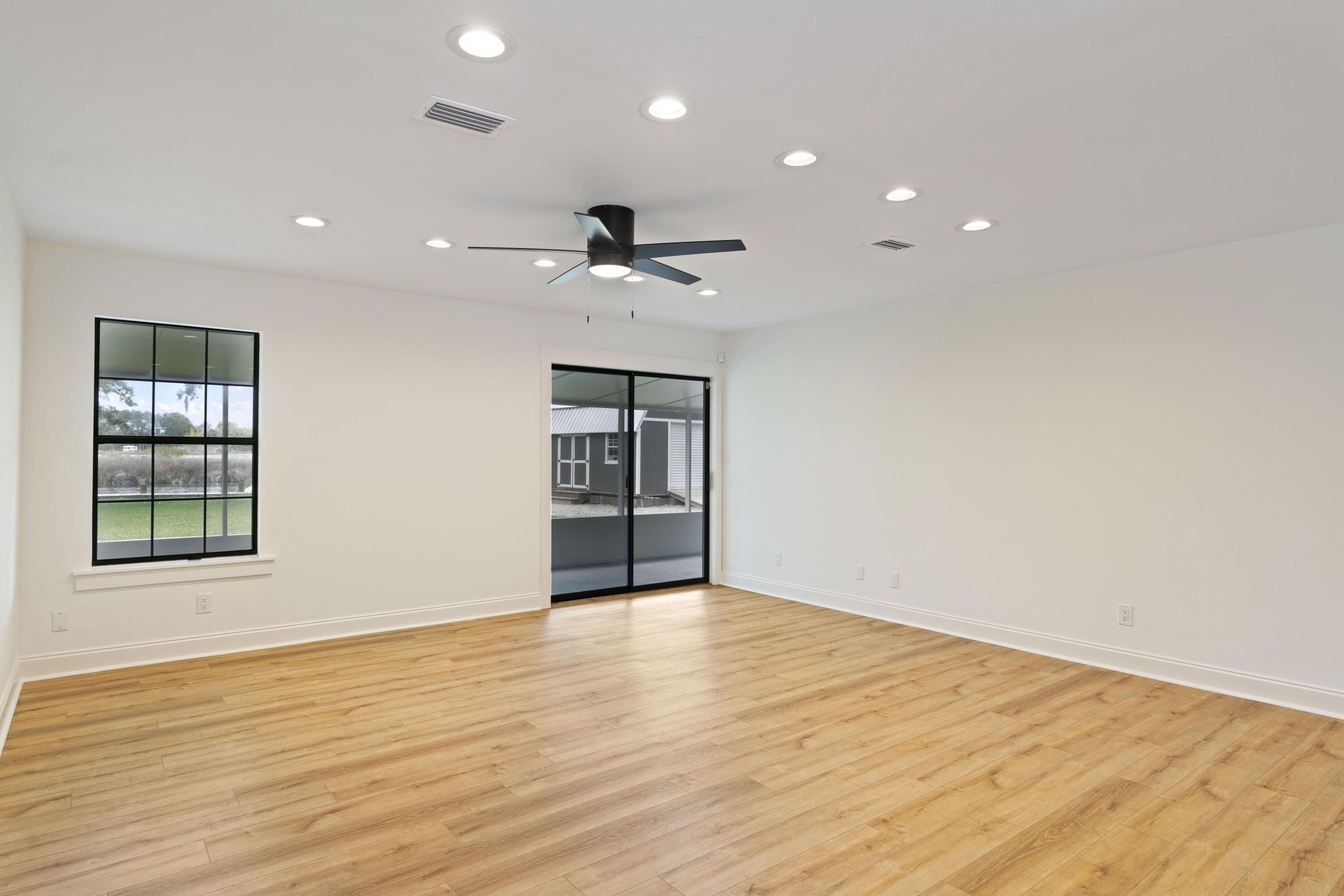 1534 Bay Grove Road Freeport, FL 32439 - Photo 14 of 33 a view of an empty room with wooden floor and a window