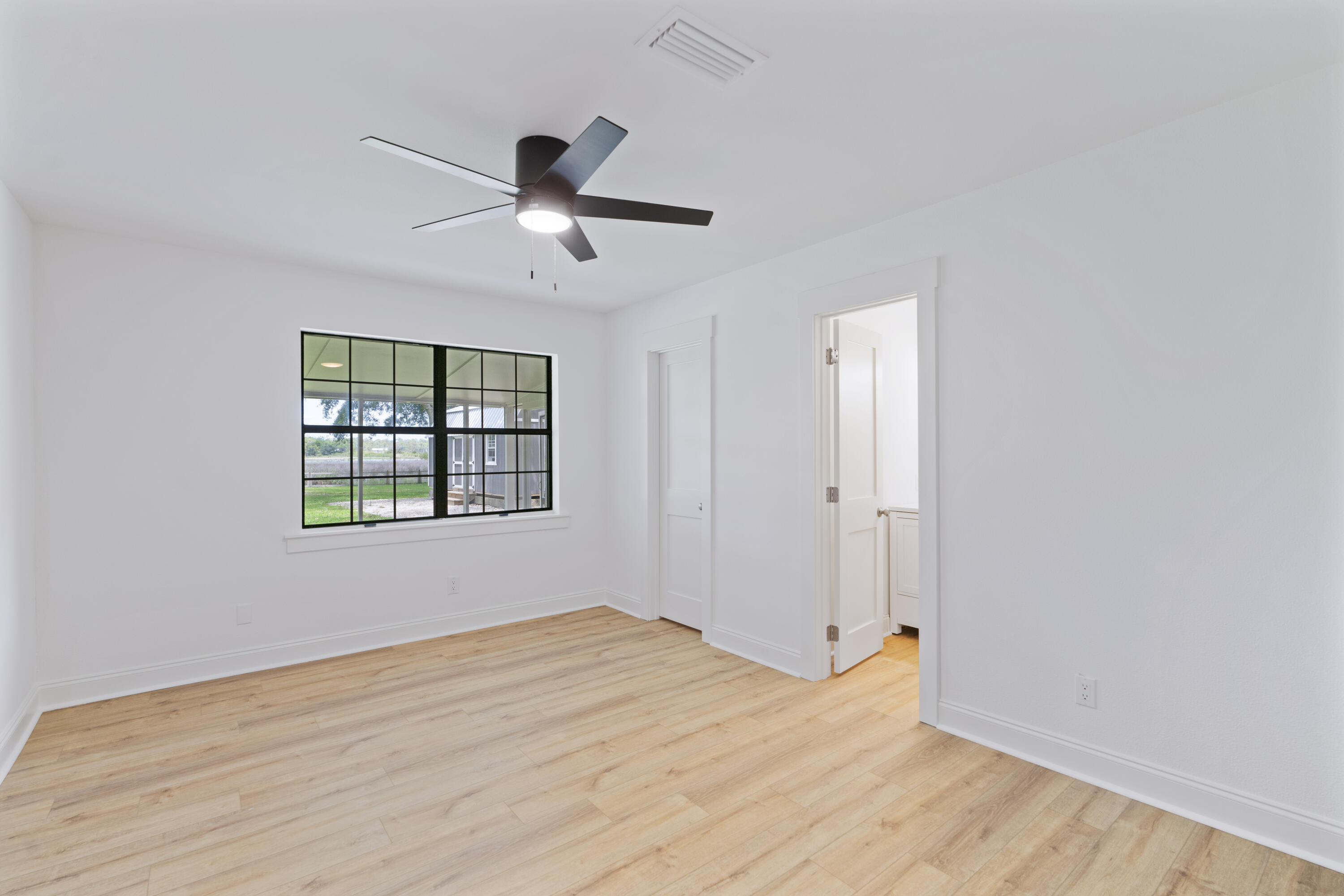1534 Bay Grove Road Freeport, FL 32439 - Photo 6 of 33 a view of empty room with wooden floor and fan