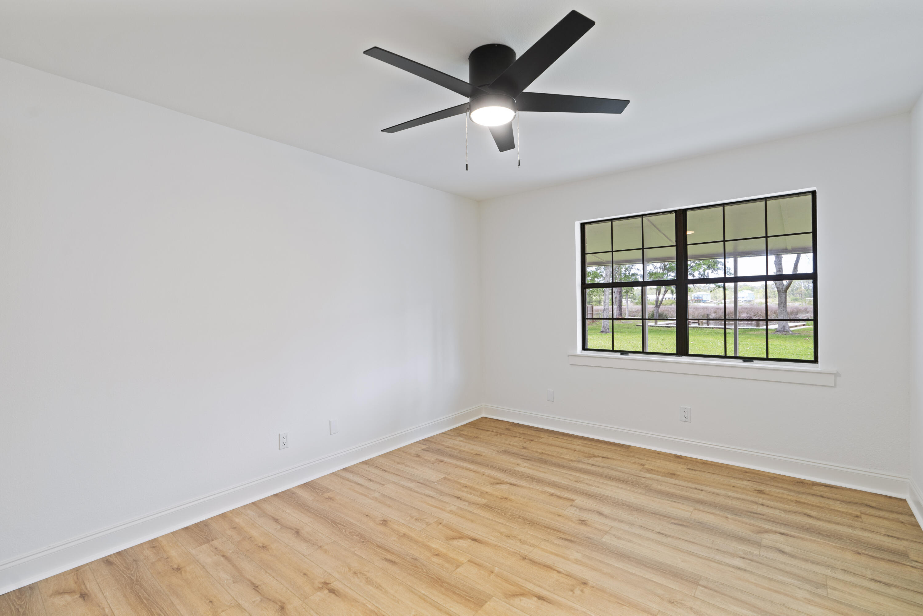 1534 Bay Grove Road Freeport, FL 32439 - Photo 7 of 33 an empty room with wooden floor and windows