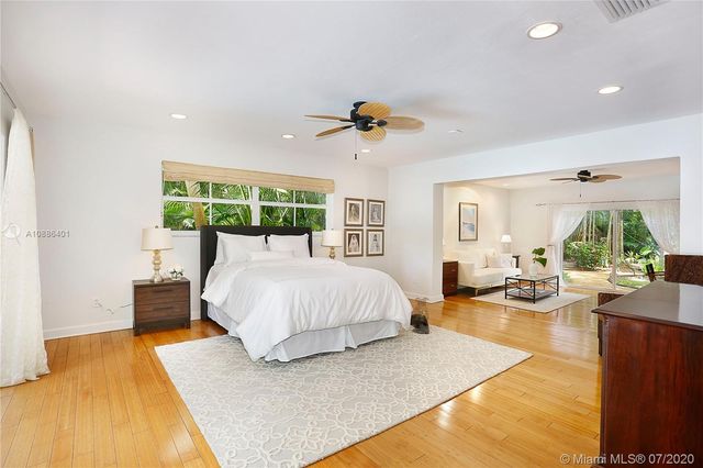 a bed room with a bed mirror and a large window