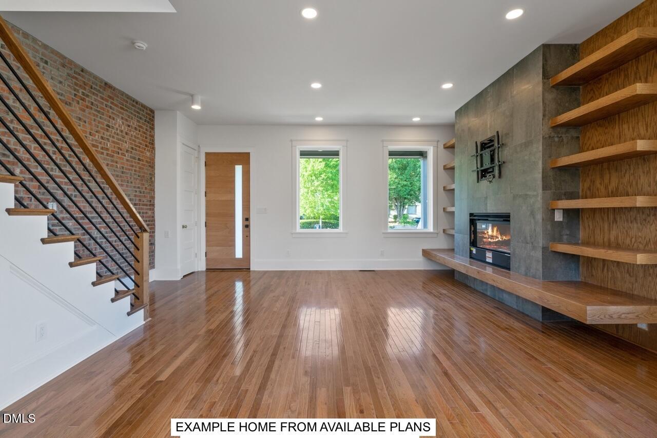 623 Velma Hopkins Lane Raleigh, NC 27603 - Photo 11 of 13 an empty room with wooden floor fireplace and windows