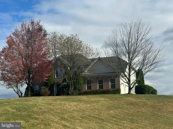 a front view of a house with a yard and trees
