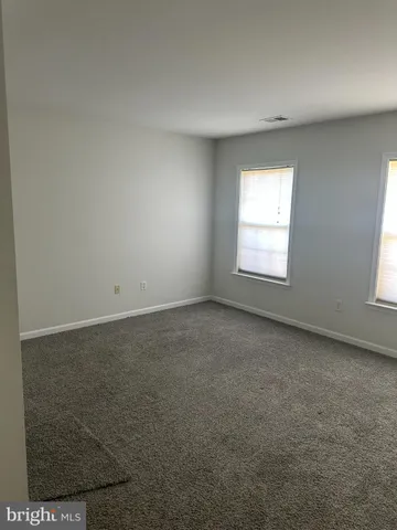 a spacious bedroom with a bed and window