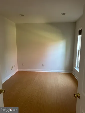a view of a hallway with wooden floor and chandelier