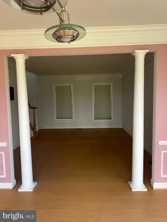 an empty room with windows and ceiling fan