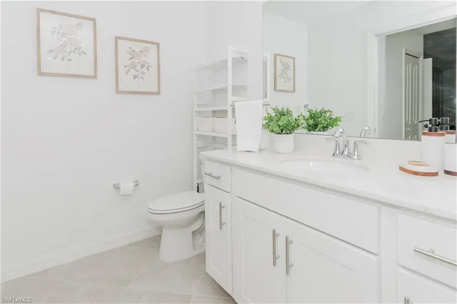 a bathroom with a granite countertop sink and a toilet
