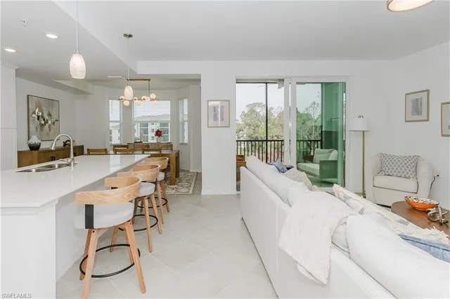 a living room with furniture a large window and white walls