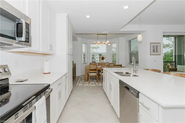 a kitchen with kitchen island a sink appliances and cabinets